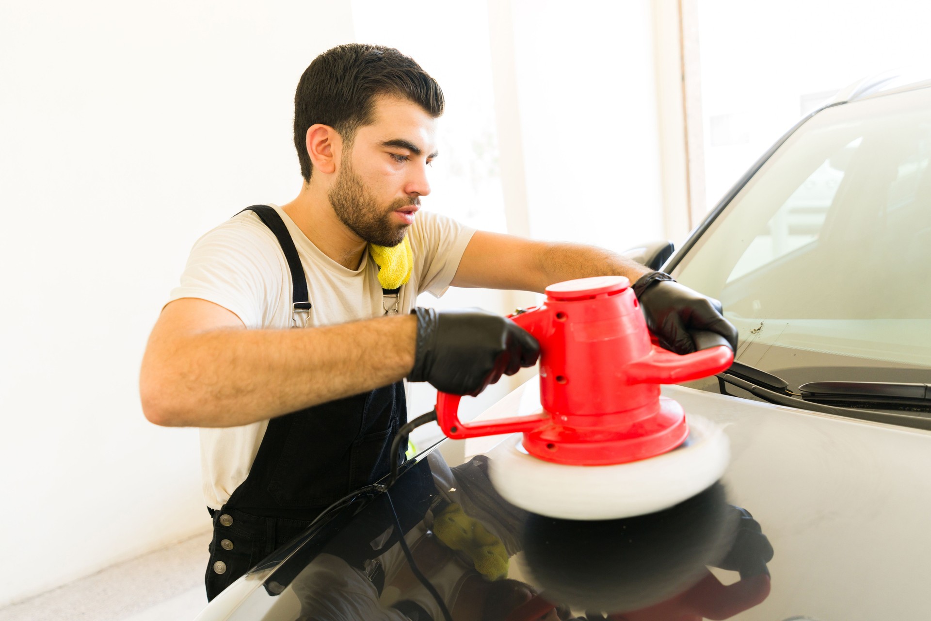 Wax car polishing with orbital polisher at auto detail service